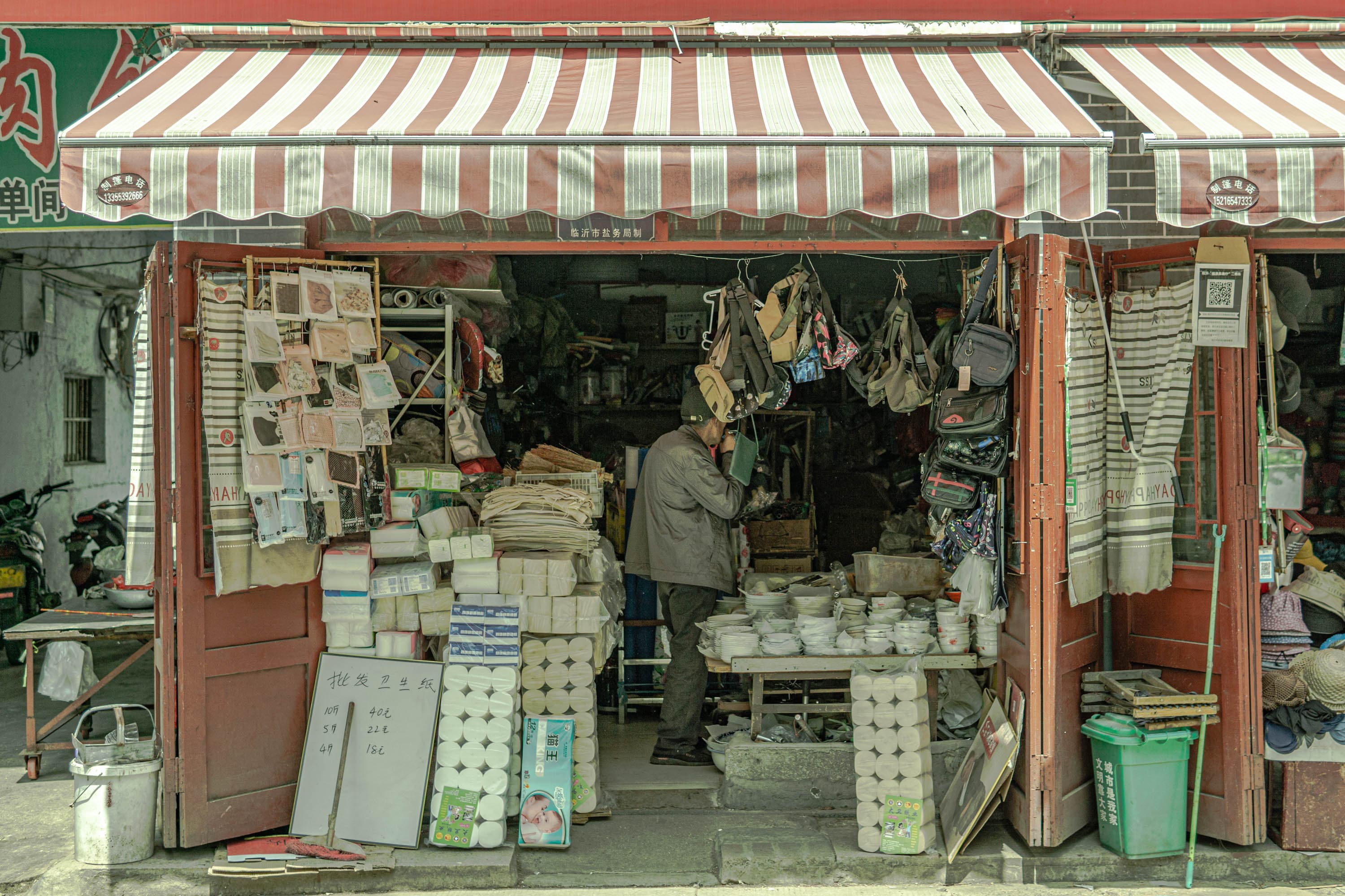 A man standing in a store selling items